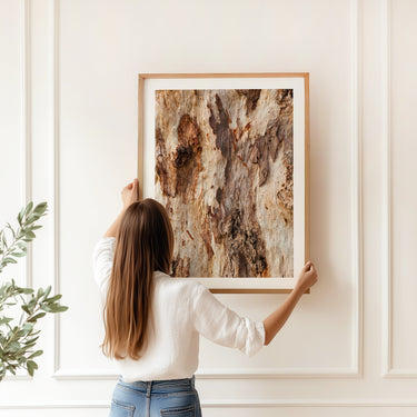 Person holding a gum tree bark photography print on a white wall